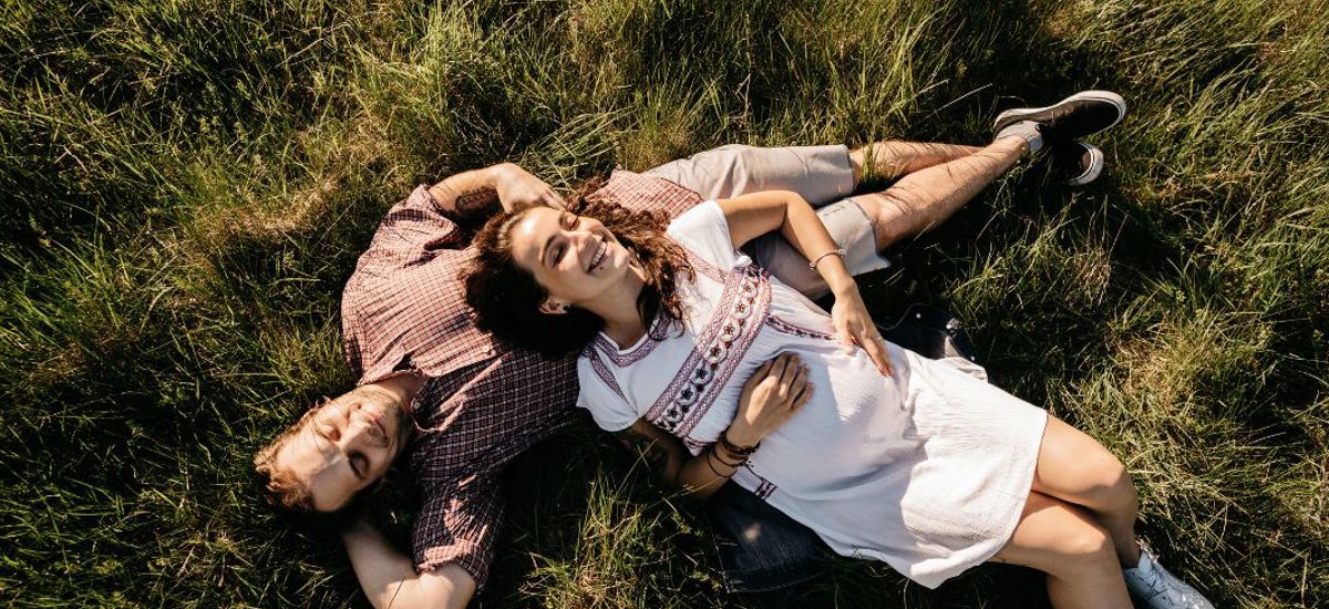 Couple enjoys the sun while lying in the grass