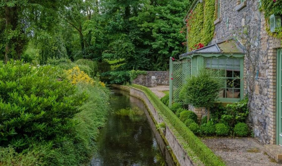 External view of irish stone cottage hotel with canal