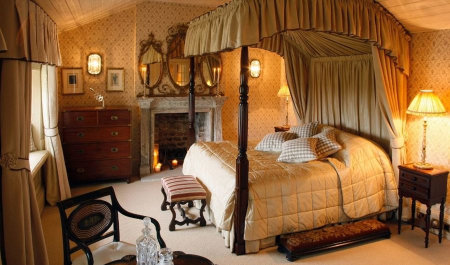 Vintage hotel room with wooden 4 post bed and quilted bed cover