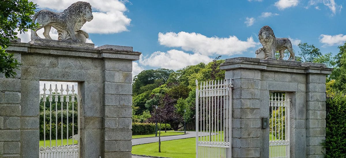 Pair od stone lion statues on country house entrance gates