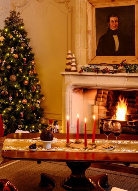 Fireplace in sitting room with christmas decorations in country cottage ireland