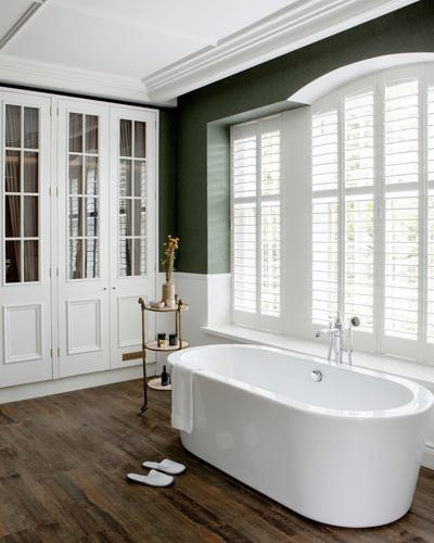 Irish cottage hotel bathroom with wood floors and white bathtub