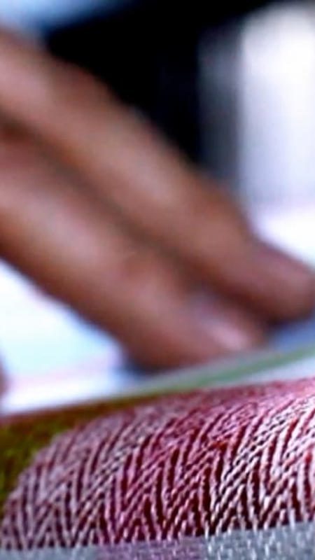 Hamd touching pattern cloth on table
