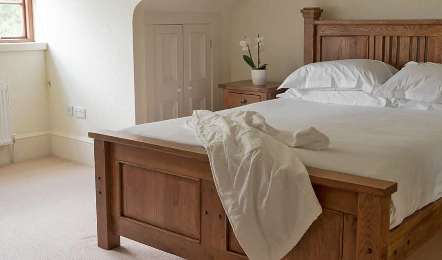 Simple elegant hotel room with timber bed and white sheets