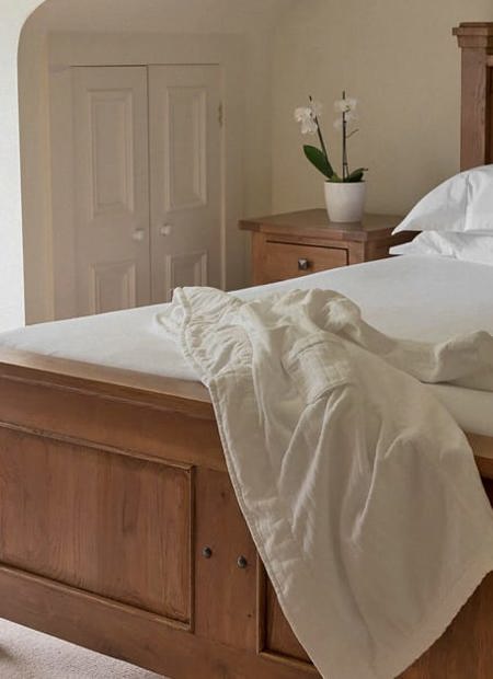 Simple elegant hotel room with timber bed and white sheets