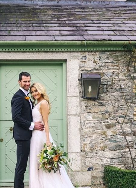 Newleywed couple pose for photos in front of irish cottage