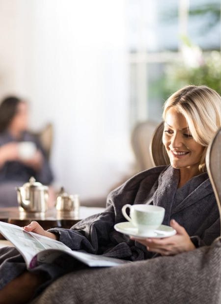 Lady reading magazine with tea at wellness spa