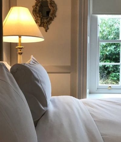 Luxurious hotel suite with garden foliage view fresh linen and white windows