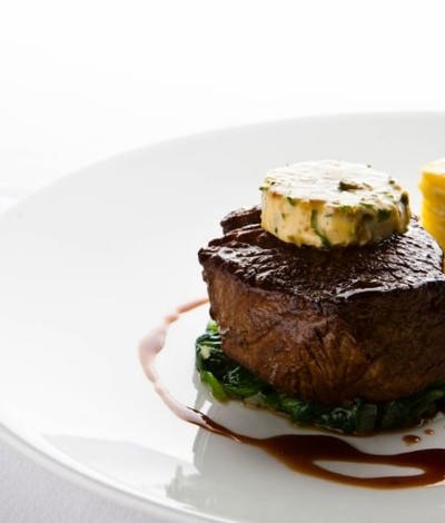 Fine dining restaurant steak with dark sauce and garlic butter