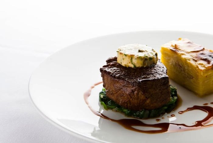 Fine dining restaurant steak with dark sauce and garlic butter