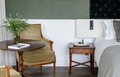 Hotel room with cushioned chairs and white linen
