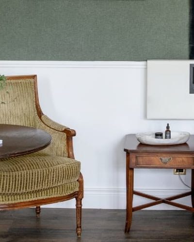 Hotel room with cushioned chairs and white linen