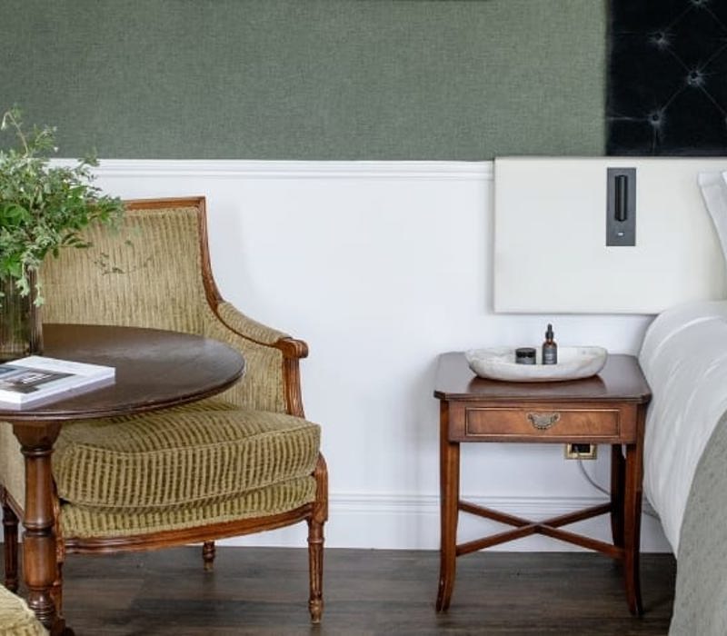 Hotel room with cushioned chairs and white linen