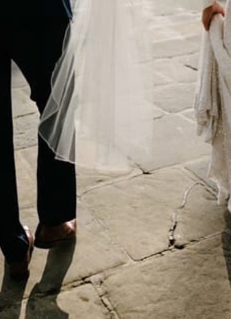 Artisitic image bride and groom sunlight veil below waist