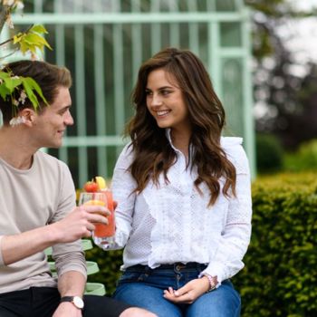 Couple share a drink on the garden at irish country house