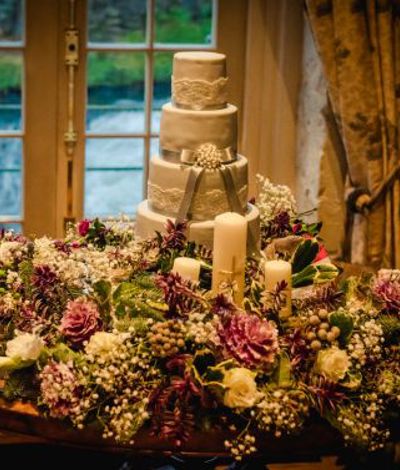 Wedding cake surrounded by bright native flowers
