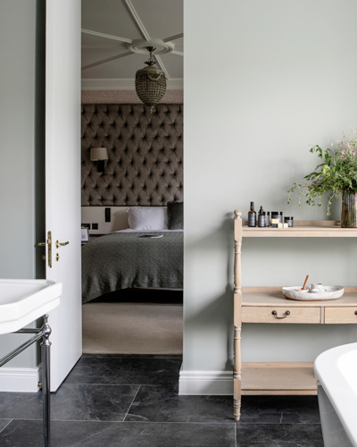 View from modern hotel bathroom to hotel suite room